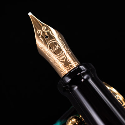 Close-up of the gold-plated 14k nib on the Aurora Optima Auroloide Emerald Green fountain pen, showing fine engravings and the Aurora logo.