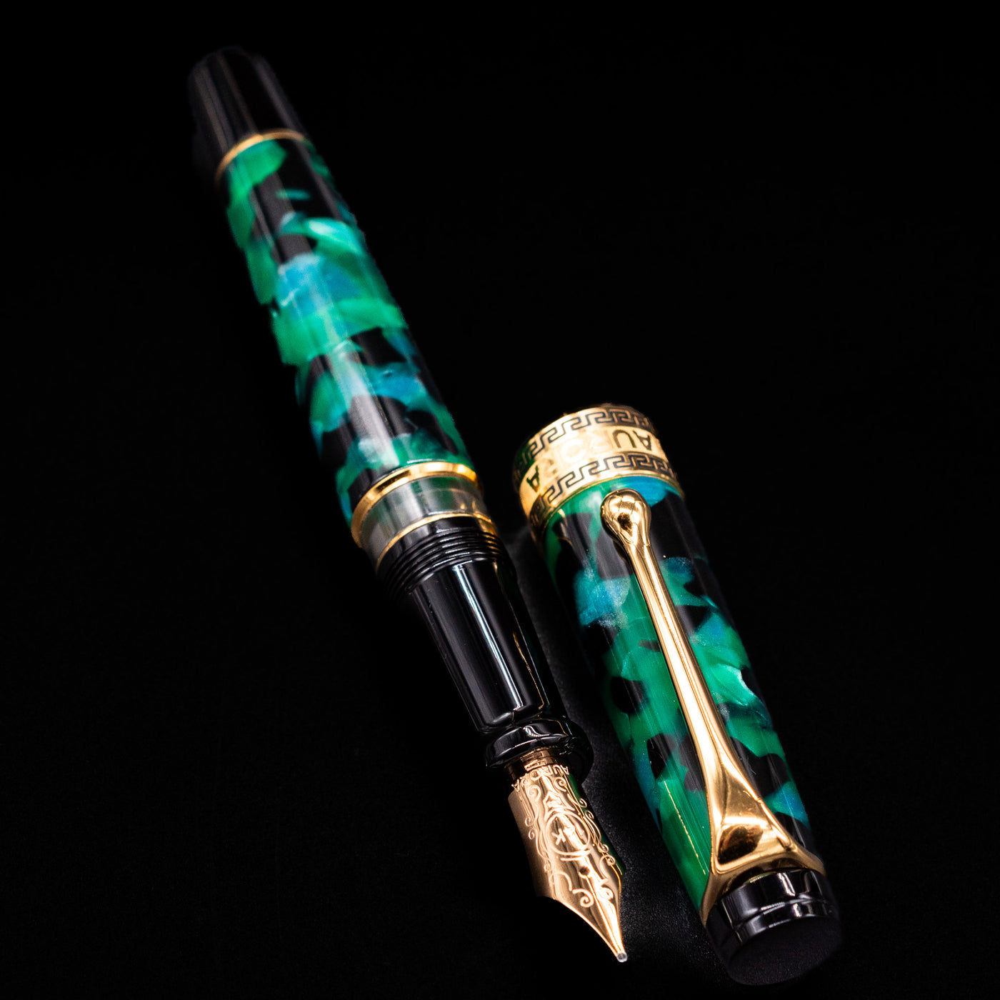Aurora Optima Auroloide Emerald Green fountain pen displayed uncapped, revealing the marbled green resin barrel, gold-plated grip section, and engraved gold nib.