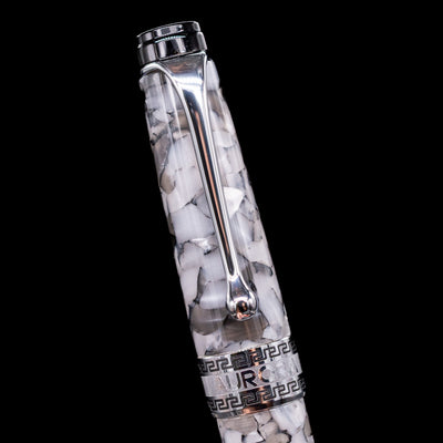 Close-up of the cap and clip of the Aurora Optima Auroloide Nero Perla fountain pen, highlighting the polished rhodium-plated clip, decorative engraved cap band, and the sophisticated marbled black-and-grey resin finish.