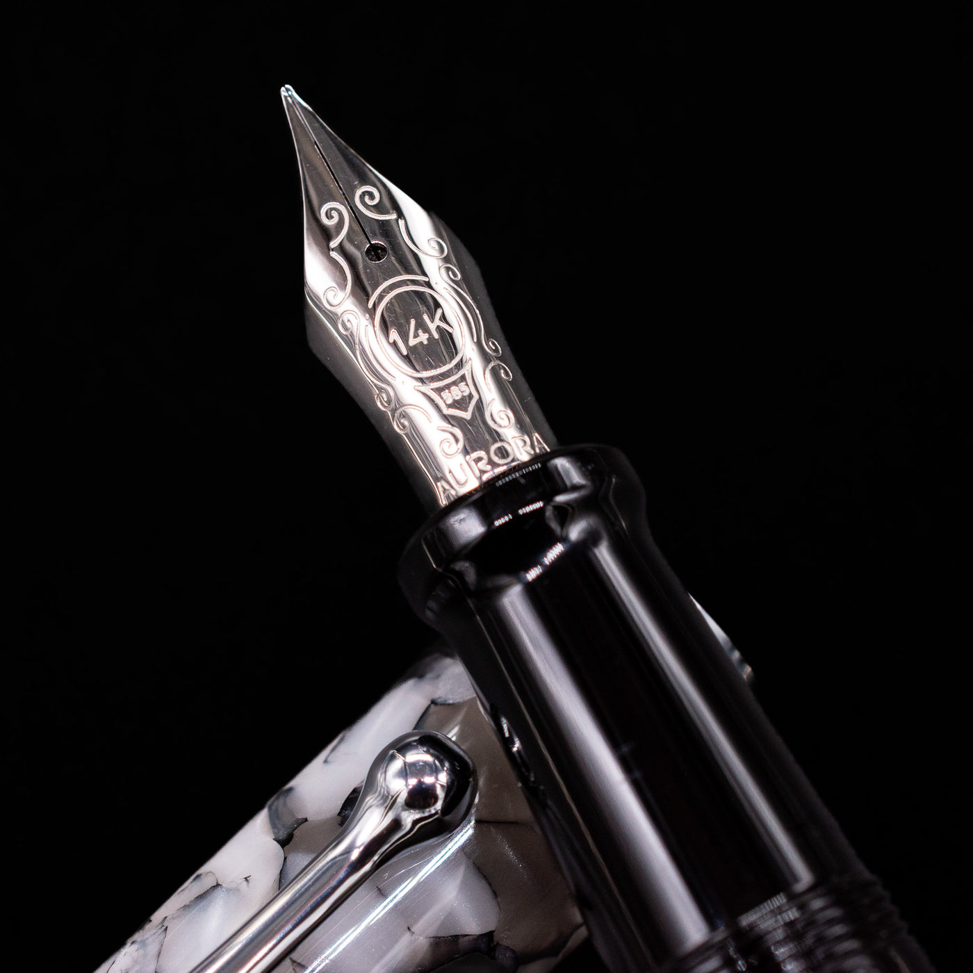 Close-up of the rhodium-plated 14k gold nib on the Aurora Optima Auroloide Nero Perla fountain pen, showing fine engravings and the Aurora logo.