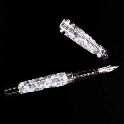 Overhead view of the Aurora Optima Auroloide Nero Perla fountain pen, emphasizing the balanced proportions, engraved cap band, and polished silver clip.