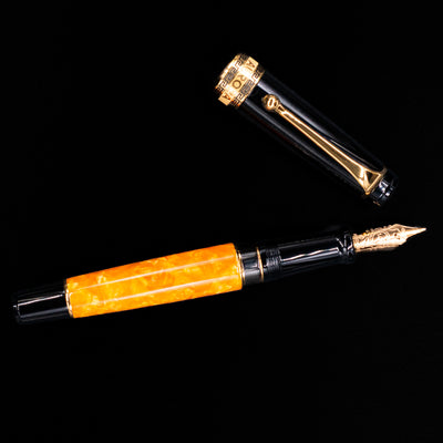 Overhead view of the Aurora Optima O Sole Mio fountain pen, emphasizing the balanced proportions, black resin cap, and polished gold clip.
