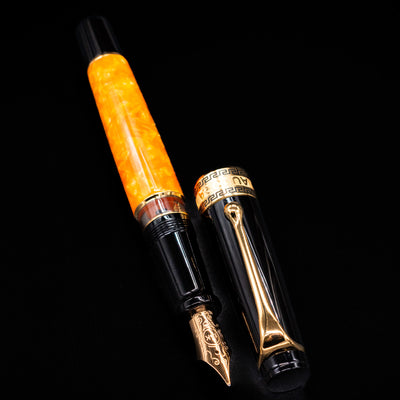 Aurora Optima O Sole Mio fountain pen displayed uncapped, revealing the bright marbled orange resin barrel, black grip section, and gold-plated trim.