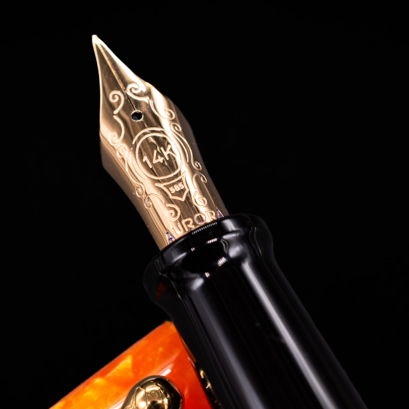 Close-up of the gold-plated 14k nib on the Aurora Optima Orange fountain pen, showing fine engravings and the Aurora logo.