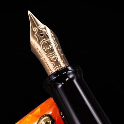 Close-up of the gold-plated 14k nib on the Aurora Optima Orange fountain pen, showing fine engravings and the Aurora logo.