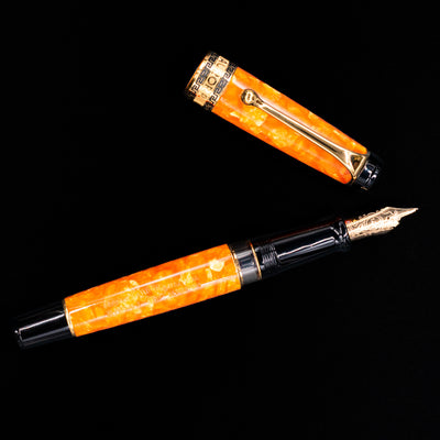 Overhead view of the Aurora Optima Orange fountain pen, emphasizing the balanced proportions, decorative cap band, and polished gold clip.