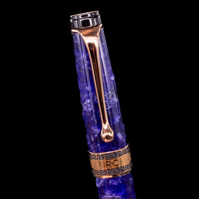 Close-up of the cap and clip of the Aurora Optima Viola fountain pen, highlighting the polished rhodium-plated clip, decorative engraved cap band, and the marbled purple resin finish.