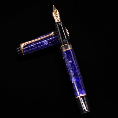Aurora Optima Viola fountain pen and cap arranged in a crossed position, showcasing the deep marbled purple finish, decorative cap band, and rhodium-plated clip.