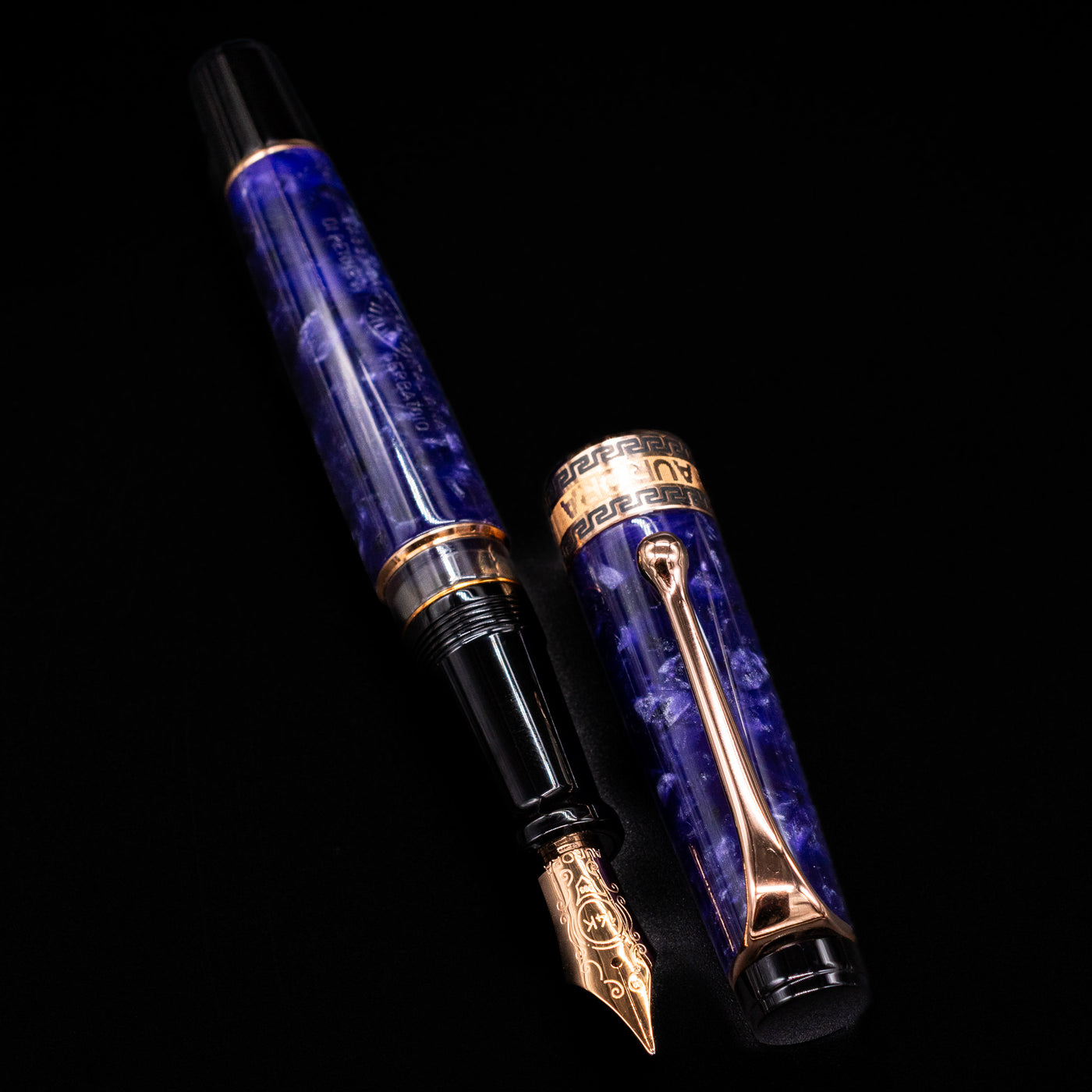 Aurora Optima Viola fountain pen displayed uncapped, revealing the marbled purple resin barrel, rhodium-plated grip section, and engraved rose gold nib.