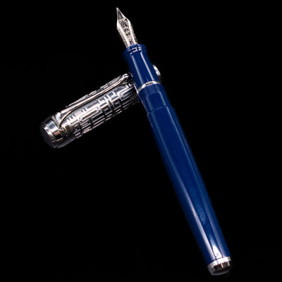 Aurora Talentum Dedalo Blue Fountain Pen - Preowned laying on top of its cap in a crossed position showing full view of the entire uncapped pen.