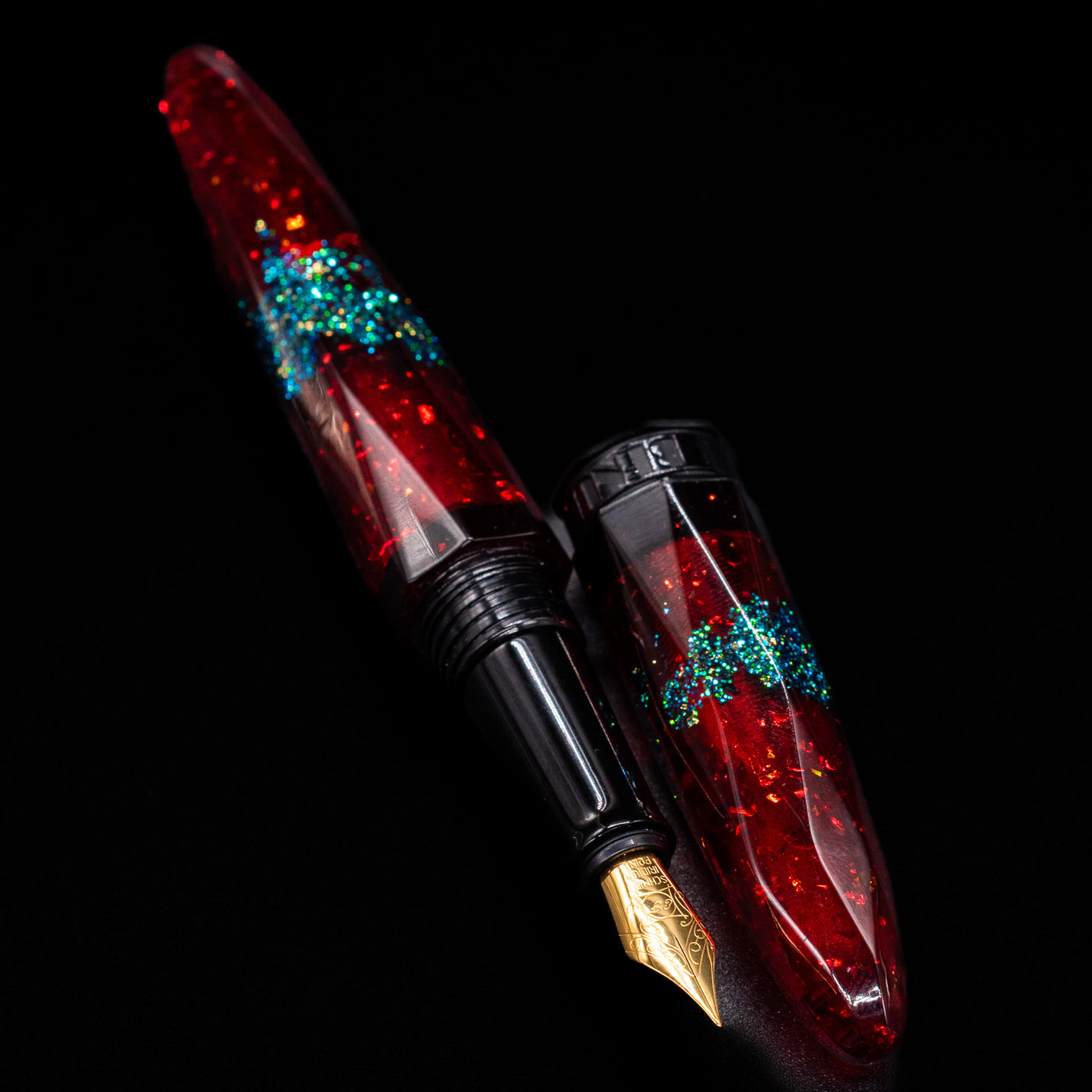 A full view of the BENU Briolette Fountain Pen - Ruby Forest uncapped, with its cap laying next to the pen. 