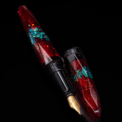 A full view of the BENU Briolette Fountain Pen - Ruby Forest uncapped, with its cap laying next to the pen. 