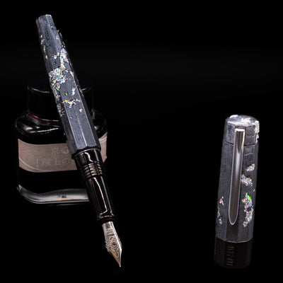 BENU Euphoria Caviar Fountain Pen leaning on an ink bottle uncapped showcasing the detailing on the nib.