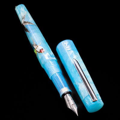 A full view of the BENU Euphoria Limited Edition Fountain Pen - Swallow’s Song uncapped, with its cap laying next to the pen. 