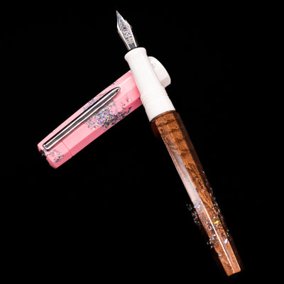 BENU Euphoria Neapolitan Ice Cream Fountain Pen - Preowned laying on top of its cap in a crossed position showing full view of the entire uncapped pen.