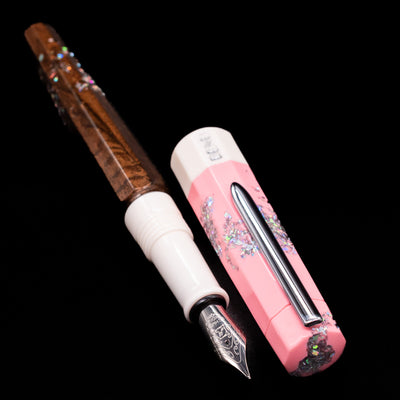 A full view of the BENU Euphoria Neapolitan Ice Cream Fountain Pen - Preowned uncapped, with its cap laying next to the pen. 