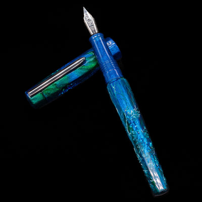 BENU Euphoria White Stag Fountain Pen laying on top of its cap in a crossed position showing full view of the entire uncapped pen.