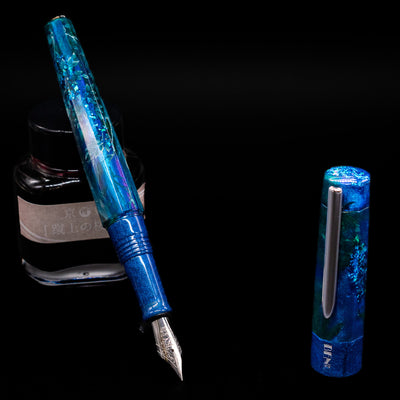 BENU Euphoria White Stag Fountain Pen leaning on an ink bottle uncapped showcasing the detailing on the nib.