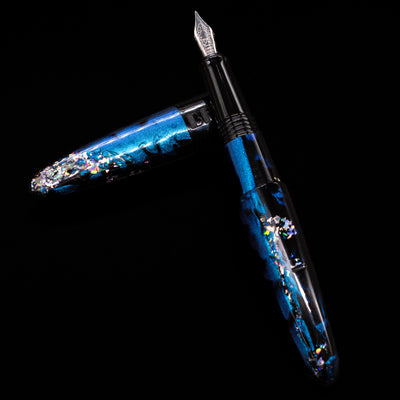 BENU Happy Chameleon Fountain Pen laying on top of its cap in a crossed position showing full view of the entire uncapped pen.