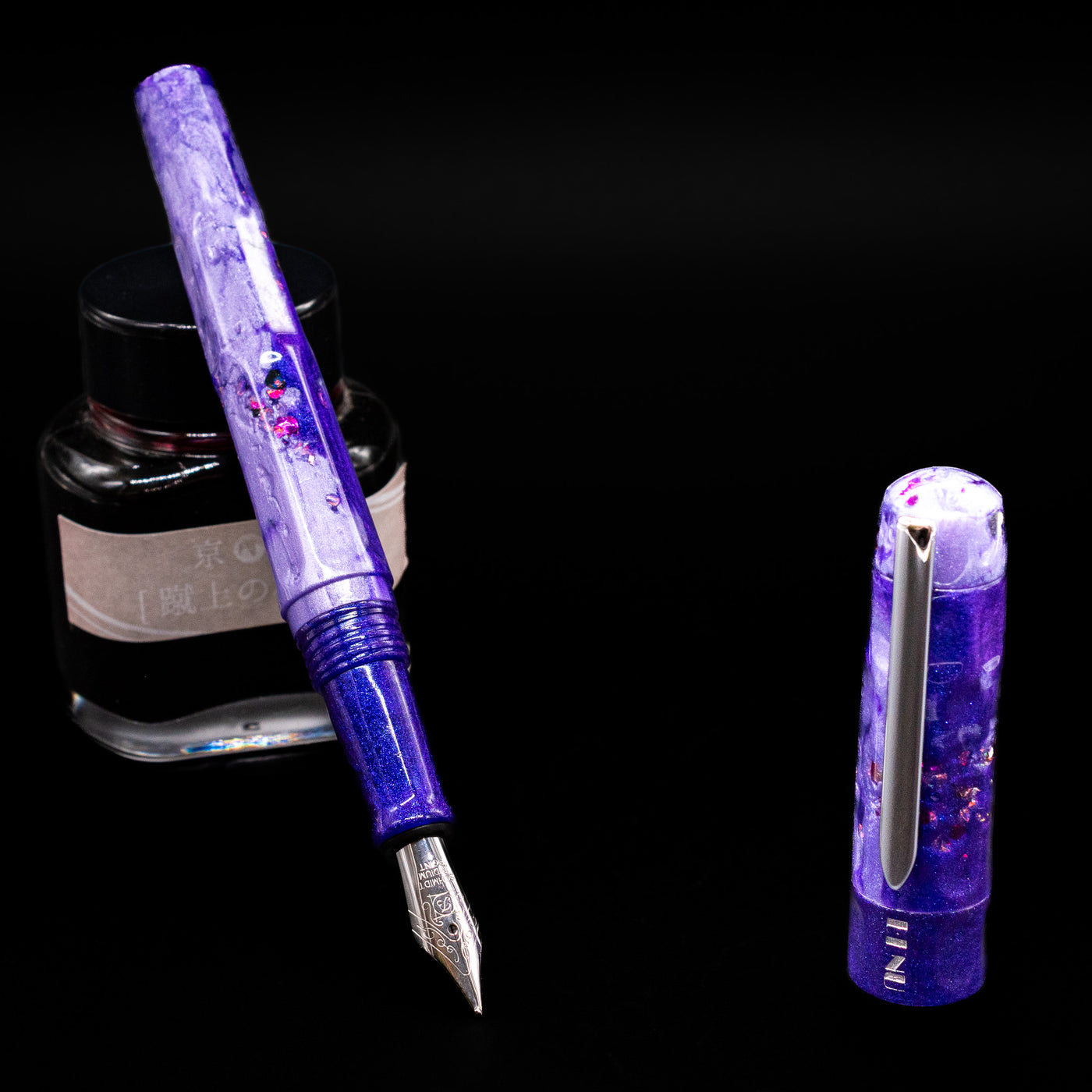 BENU Talisman Limited Edition Fountain Pen - Lavender leaning on an ink bottle uncapped showcasing the detailing on the nib.