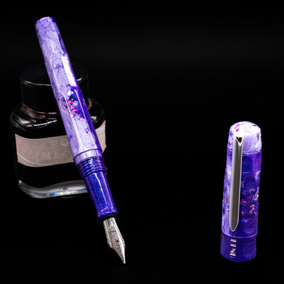 BENU Talisman Limited Edition Fountain Pen - Lavender leaning on an ink bottle uncapped showcasing the detailing on the nib.
