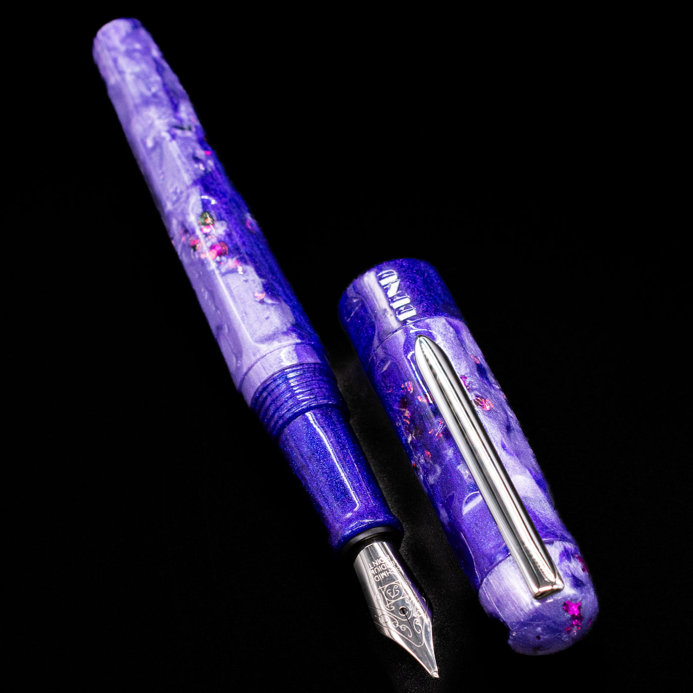  A full view of the BENU Talisman Limited Edition Fountain Pen - Lavender uncapped, with its cap laying next to the pen. 