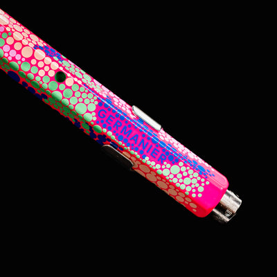 Close-up of the back end of the Caran d’Ache 849 Special Edition Germanier Fluo Pink ballpoint pen, focusing on the silver push-button mechanism and the clean transition to the fluorescent pink body.
