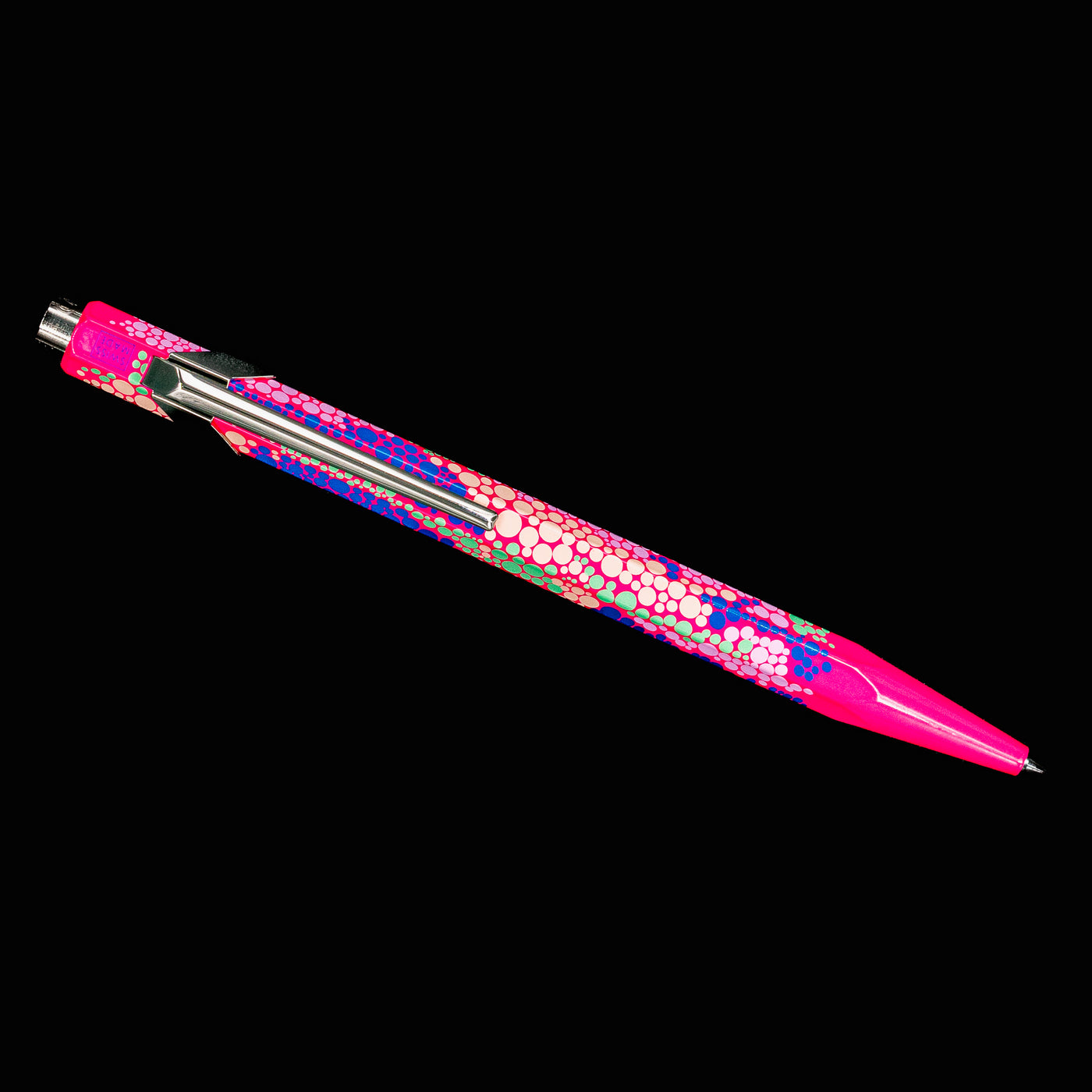 Overhead view of the Caran d’Ache 849 Special Edition Germanier Fluo Pink ballpoint pen, showing the slim, elongated silhouette and bright fluorescent pink body.