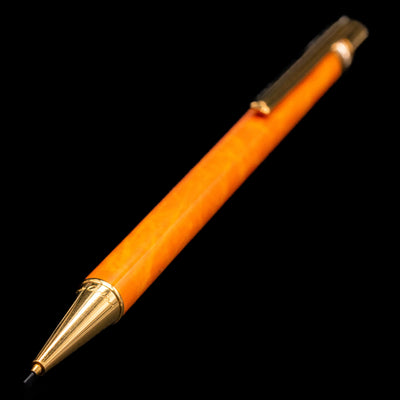 A full view of the Cartier Trinity Orange Mechanical Pencil - Preowned with a focus on the activated tip.