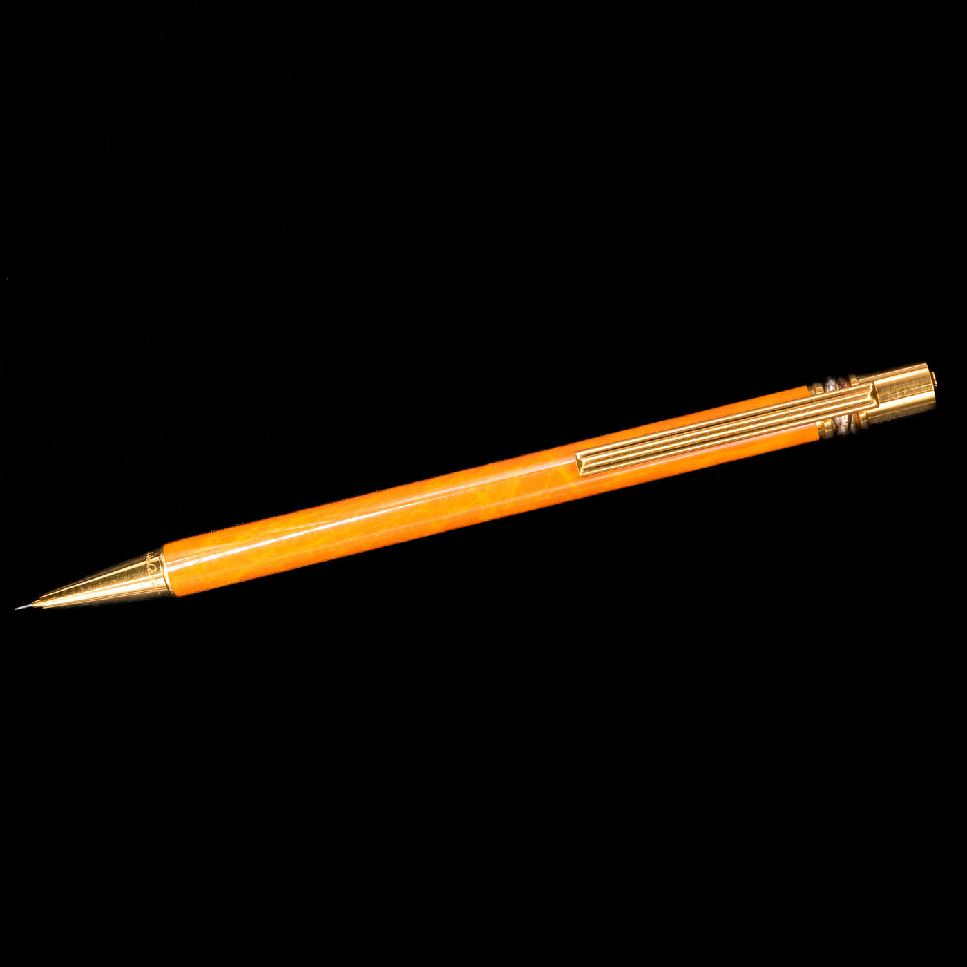 An overhead view of the Cartier Trinity Orange Mechanical Pencil - Preowned.