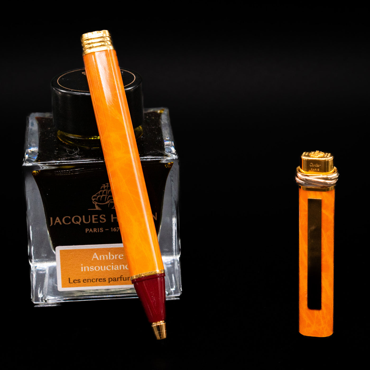 Cartier Vendome Oval Orange Fineliner Pen - Preowned leaning on an ink bottle uncapped showcasing the detailing on the tip.