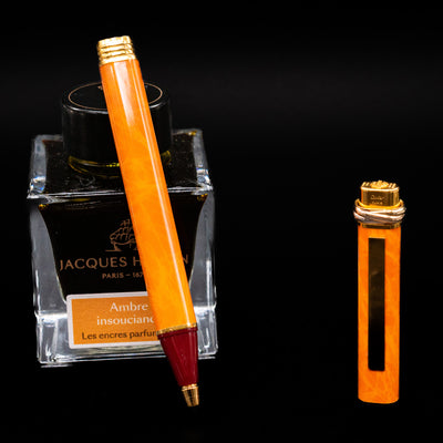 Cartier Vendome Oval Orange Fineliner Pen - Preowned leaning on an ink bottle uncapped showcasing the detailing on the tip.