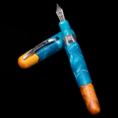 Conklin 1898 Fountain Pen - Spectra Fusion Blue laying on top of its cap in a crossed position showing full view of the entire uncapped pen.