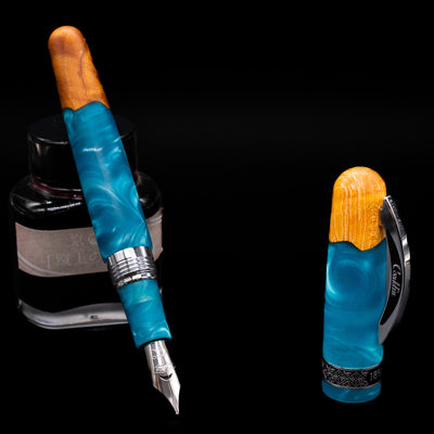 Conklin 1898 Fountain Pen - Spectra Fusion Blue leaning on an ink bottle uncapped showcasing the detailing on the nib.