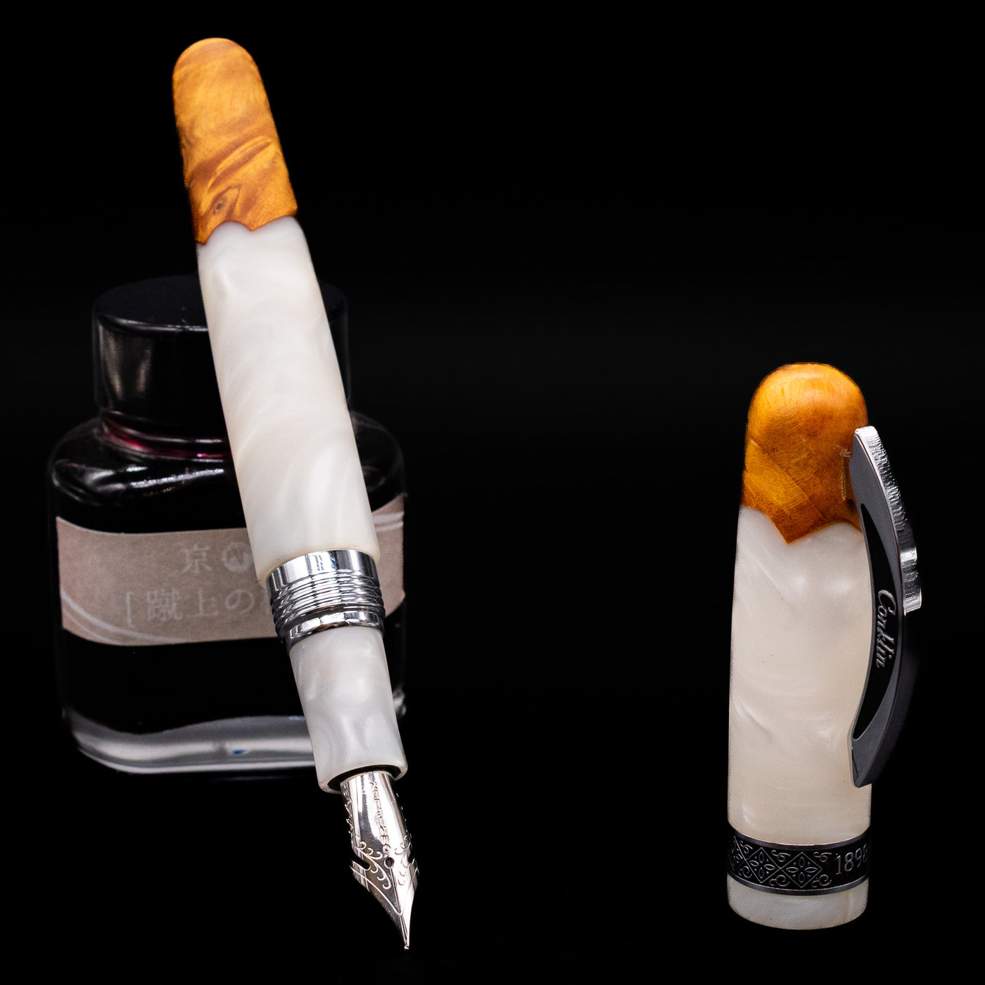 Conklin 1898 Fountain Pen - Spectra Fusion White leaning on an ink bottle uncapped showcasing the detailing on the nib.