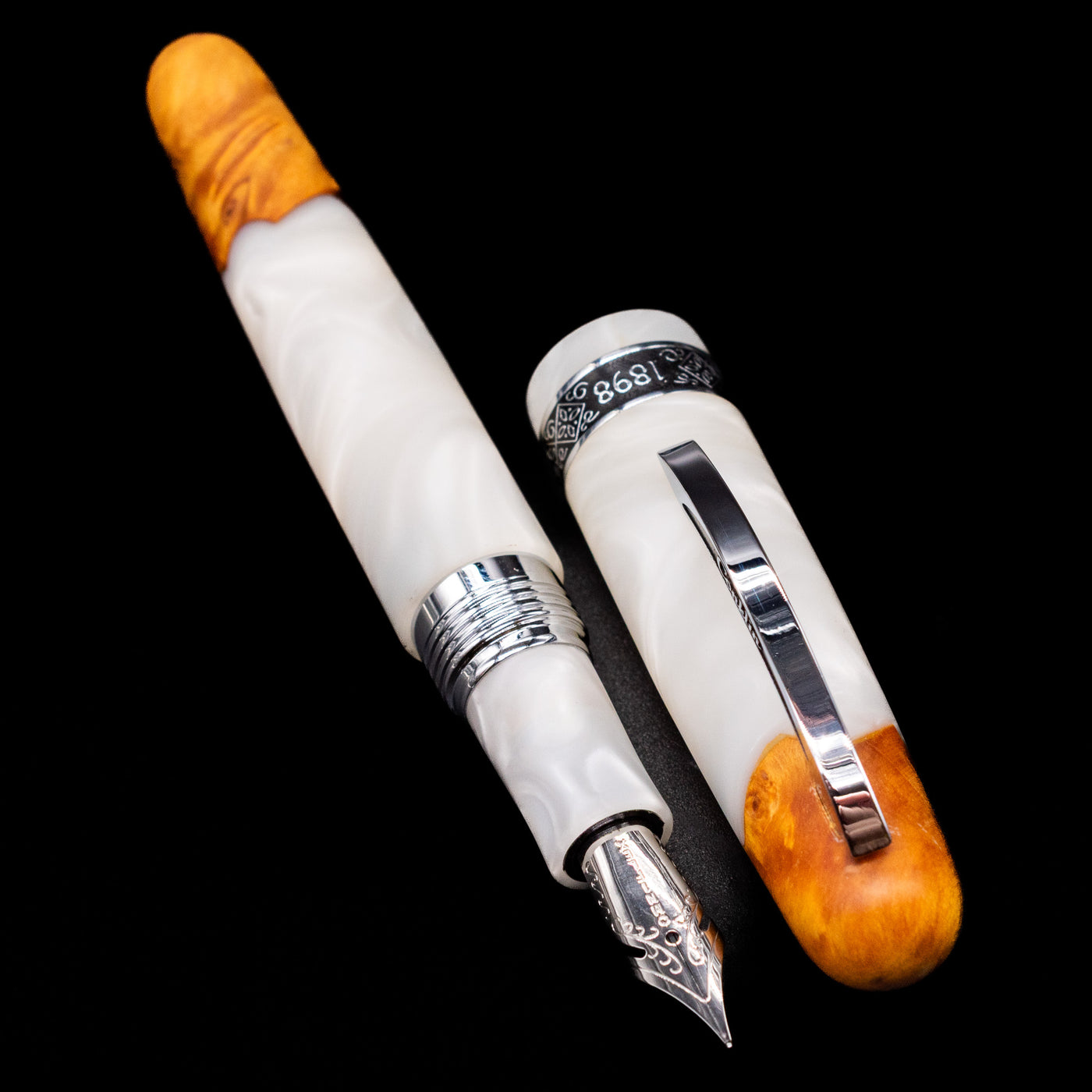 A full view of the Conklin 1898 Fountain Pen - Spectra Fusion White uncapped, with its cap laying next to the pen. 