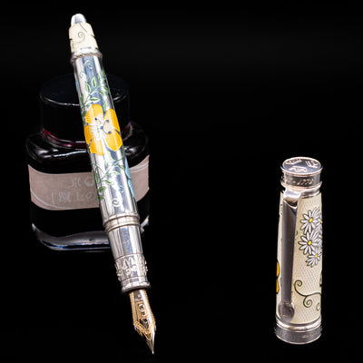 David Oscarson Carl Linnaeus Fountain Pen - White leaning on an ink bottle uncapped showcasing the detailing on the nib.
