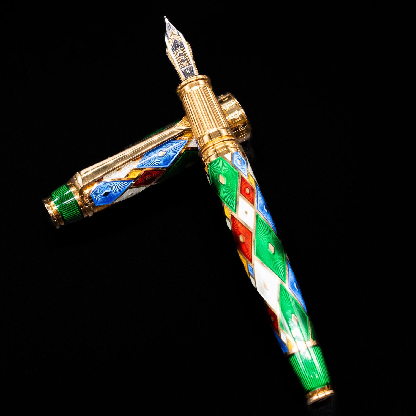 David Oscarson Harlequin Fountain Pen - Emerald Green laying on top of its cap in a crossed position showing full view of the entire uncapped pen.