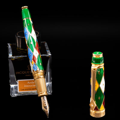 David Oscarson Harlequin Fountain Pen - Emerald Green leaning on an ink bottle uncapped showcasing the detailing on the nib.