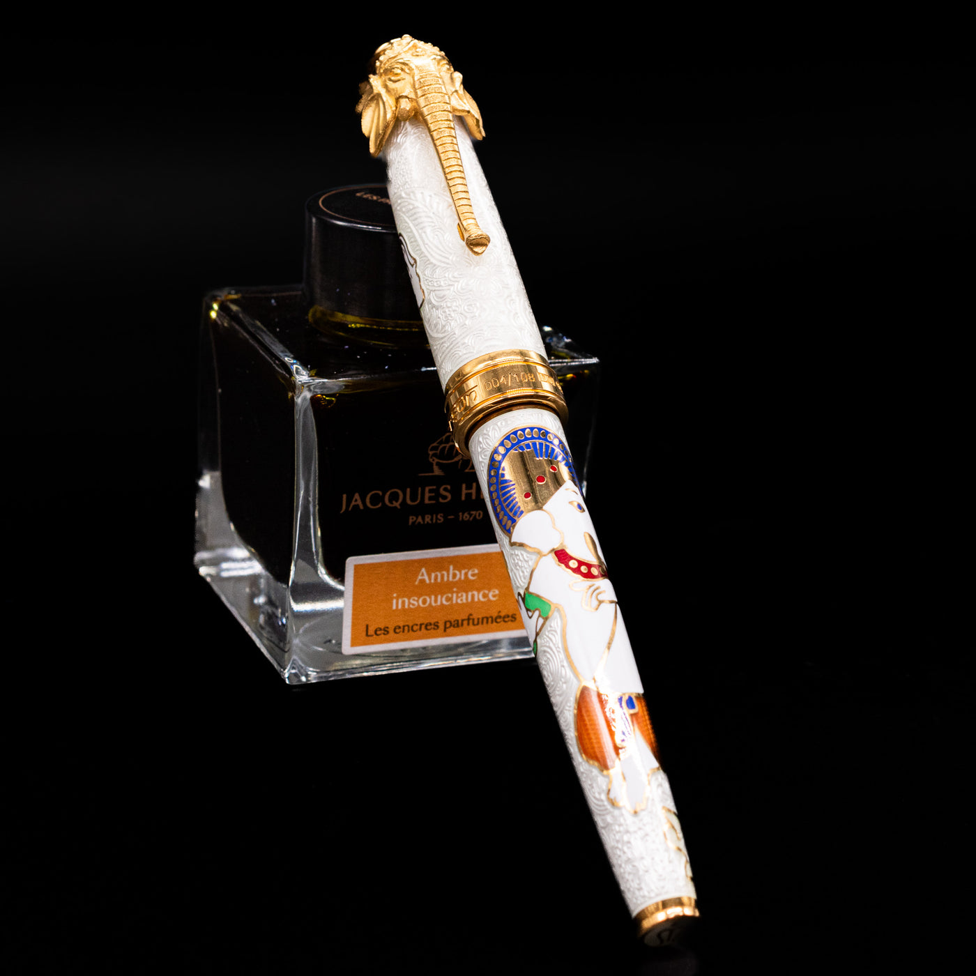 David Oscarson Lord Ganesha Fountain Pen - White capped, leaning against an ink bottle. 