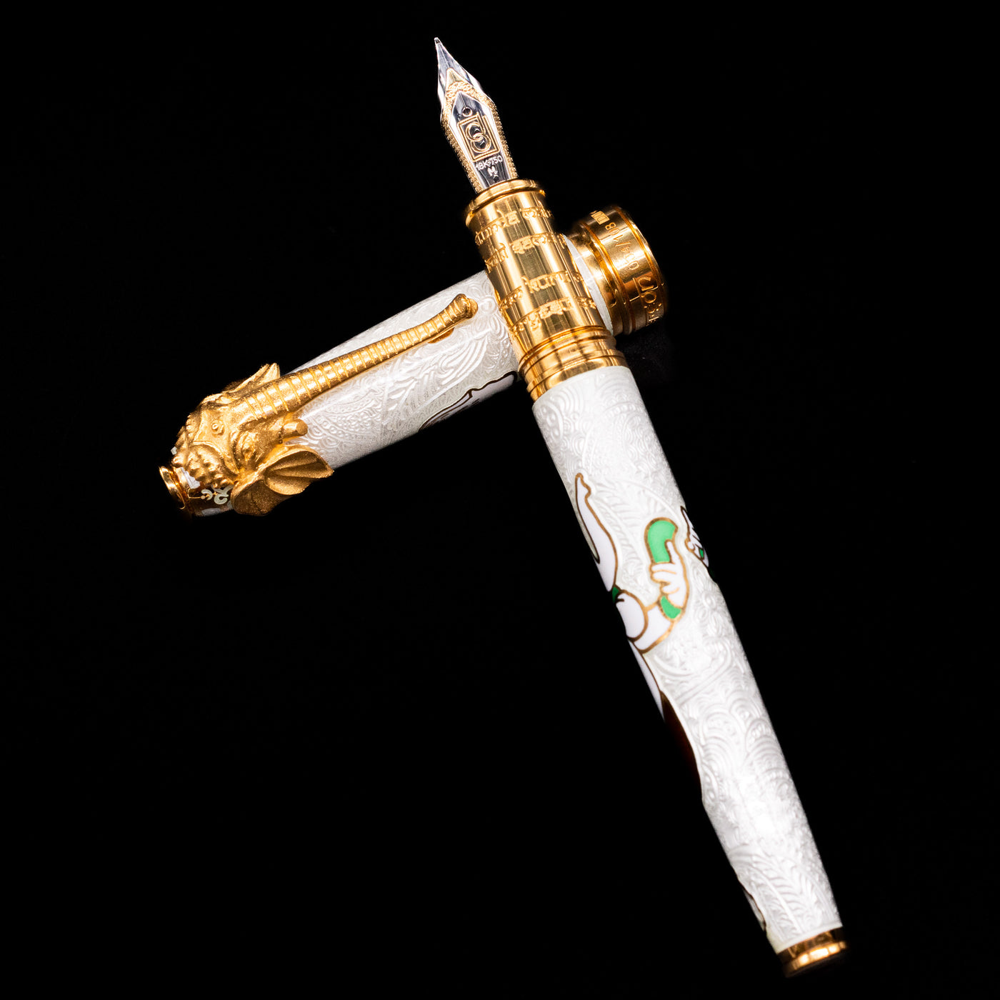 David Oscarson Lord Ganesha Fountain Pen - White laying on top of its cap in a crossed position showing full view of the entire uncapped pen.