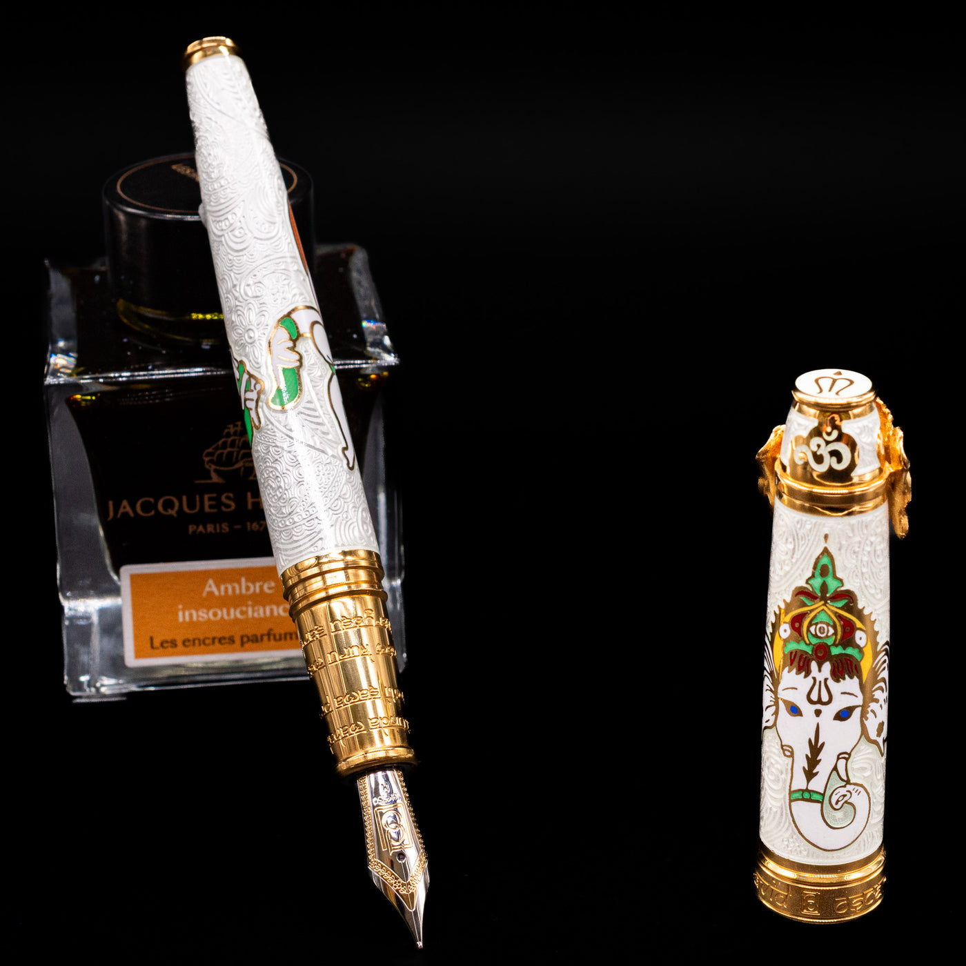 David Oscarson Lord Ganesha Fountain Pen - White leaning on an ink bottle uncapped showcasing the detailing on the nib.