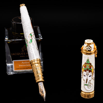 David Oscarson Lord Ganesha Fountain Pen - White leaning on an ink bottle uncapped showcasing the detailing on the nib.