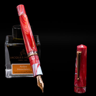 Delta Duna Fountain Pen - Ghibli leaning on an ink bottle uncapped showcasing the detailing on the nib.