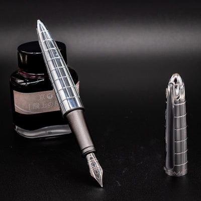 Diplomat Aero Rhomb fountain pen displayed upright with stainless steel nib, ink bottle, and chrome cap – sleek gift-worthy fountain pen