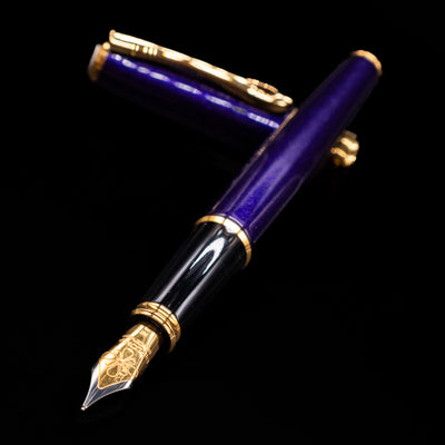 Diplomat Excellence A2 Fountain Pen - Deep Purple laying across its own cap, crossed, with a focus on the nib.