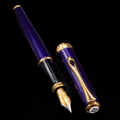 A full view of the Diplomat Excellence A2 Fountain Pen - Deep Purple uncapped, with its cap laying next to the pen. 