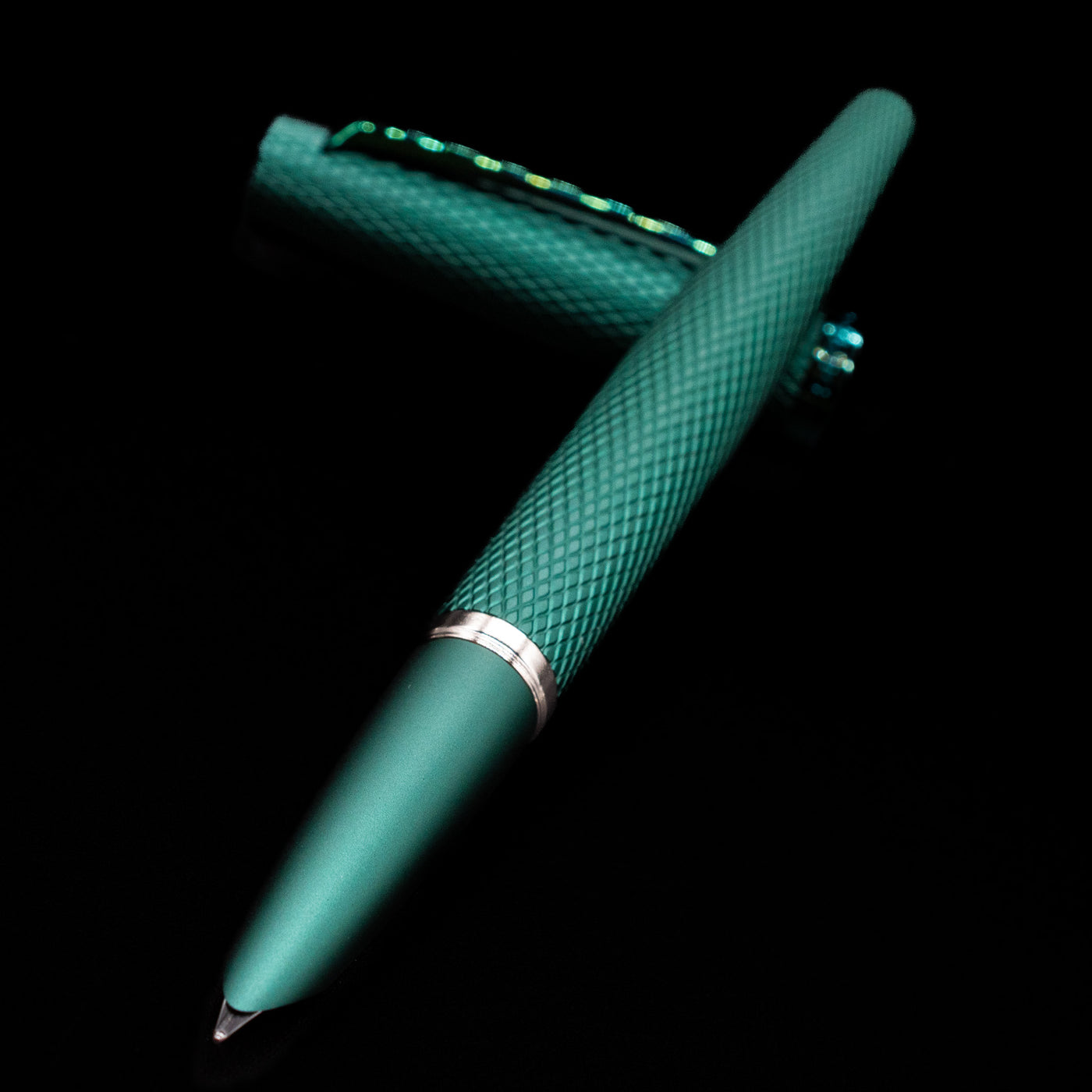 Diplomat Viper Fountain Pen - Green laying across its own cap, crossed, with a focus on the nib.