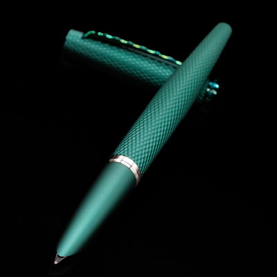 Diplomat Viper Fountain Pen - Green laying across its own cap, crossed, with a focus on the nib.