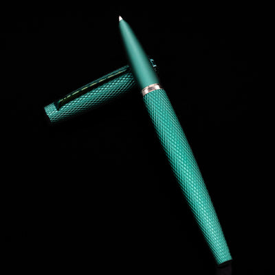 Diplomat Viper Fountain Pen - Green  laying on top of its cap in a crossed position showing full view of the entire uncapped pen.